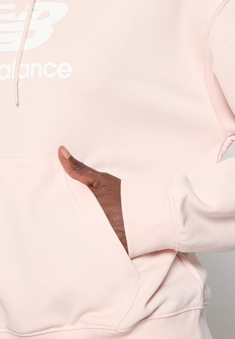 Sudadera rosa claro con logo blanco, cordón ajustable y bolsillo canguro. La textura suave y los puños acanalados mejoran el ajuste y la comodidad.