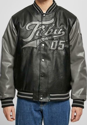 Chaqueta bomber de cuero negro con mangas grises, que presenta un logotipo destacado, botones a presión y puños y dobladillo de canalé a rayas.