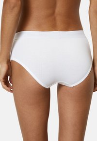 Culotte en coton blanc avec une texture lisse, dotée d'une ceinture douce embossée avec "Marc O'Polo". Conçue pour une couverture complète et un confort optimal.