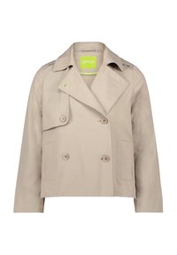 Beige dubbelzijdig jasje met een puntige kraag, zijzakken en een groene logo-tag. Gemaakt van gladde stof met een iets gestructureerde vorm.