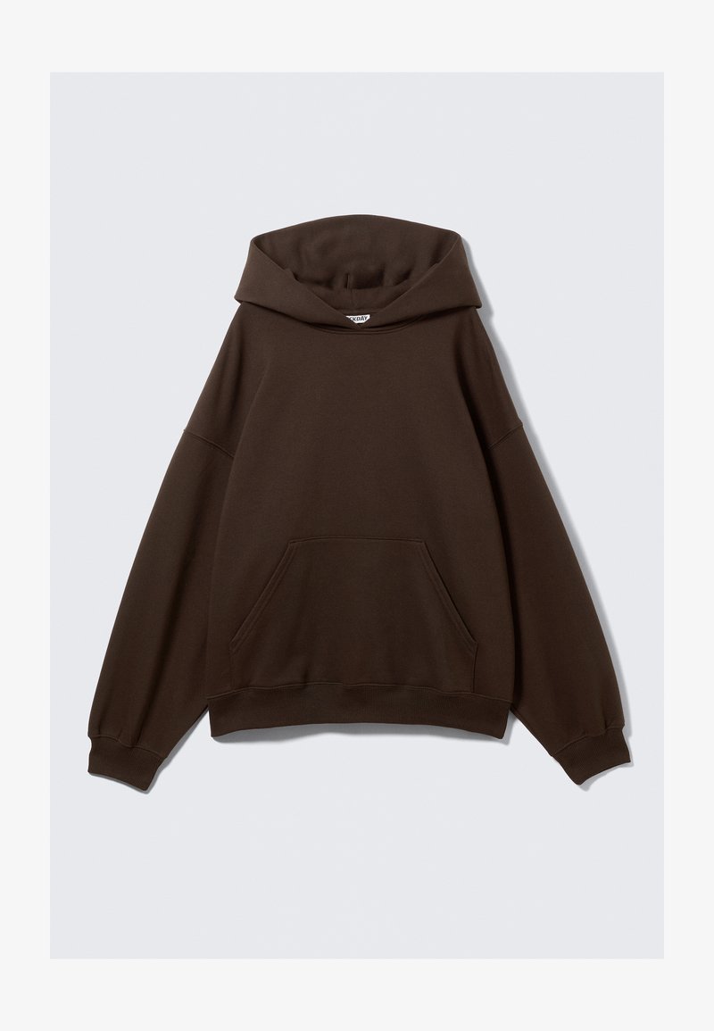 Ruskea ylisuuri huppari, joka on valmistettu puuvillasekoitekankaasta. Siinä on suuri huppu, etutasku ja ribbireunat. Sujuva pinta ja minimaalinen muotoilu.