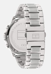 Montre en acier inoxydable argenté avec un bracelet à maillons poli et un boîtier circulaire. Présente un fond en acier inoxydable uni avec des détails de logo.