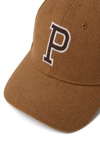 Braune Filz-Baseballmütze mit einem runden Schirm, die ein gesticktes weißes "P"-Logo trägt. Nähte sind entlang des Schirms und der Kanten der Mütze sichtbar.