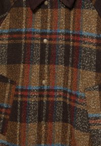 Károvaná vlnená košeľa s vrchným dielom v hnedých, modrých a červených tónoch s textúrovaným povrchom, so zapínaním na cvoky a dvoma prednými vreckami.
