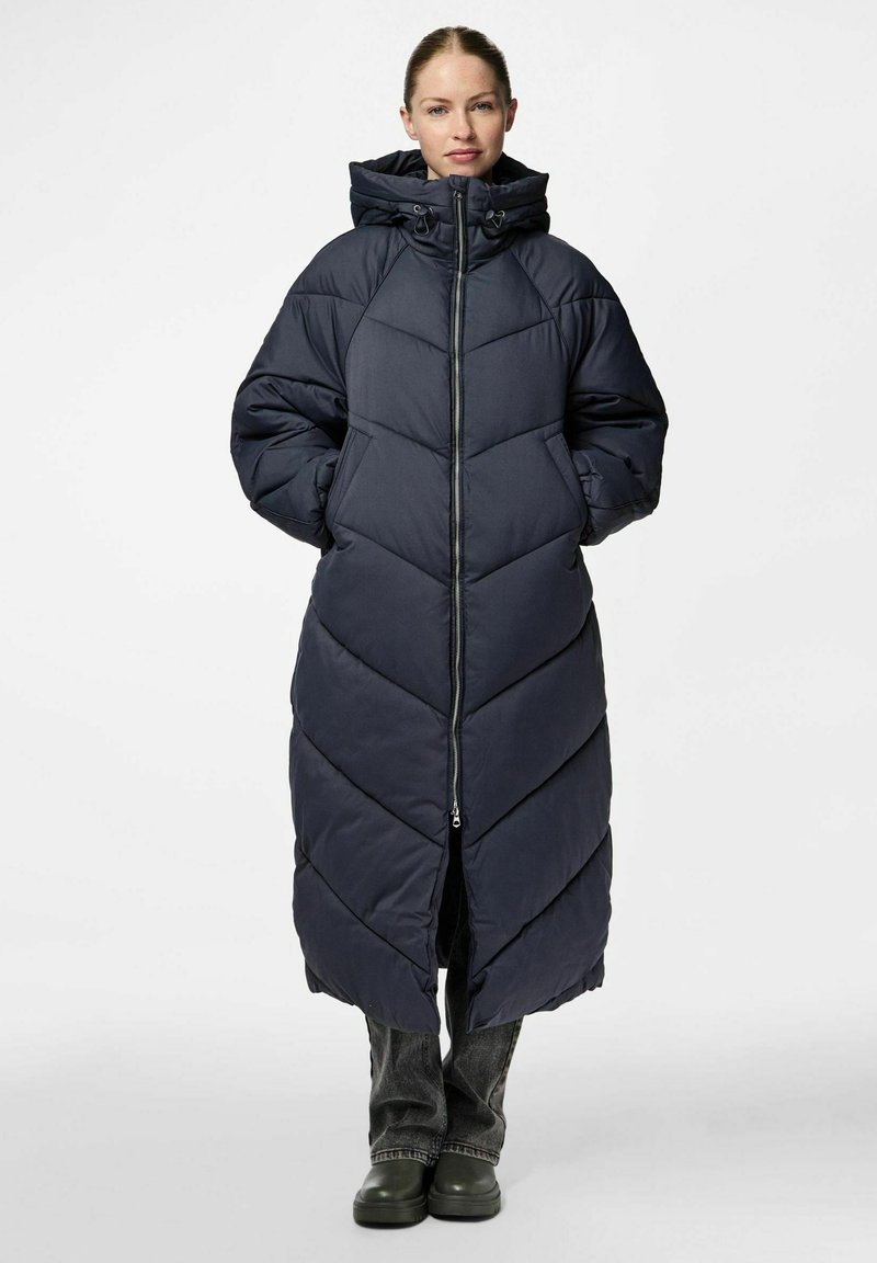 Dlouhý, námořnický puffer kabát s kapucí, zdobený šípovým vzorem, předním zipem a bočními kapsami. Materiál se zdá být hladký a izolační.