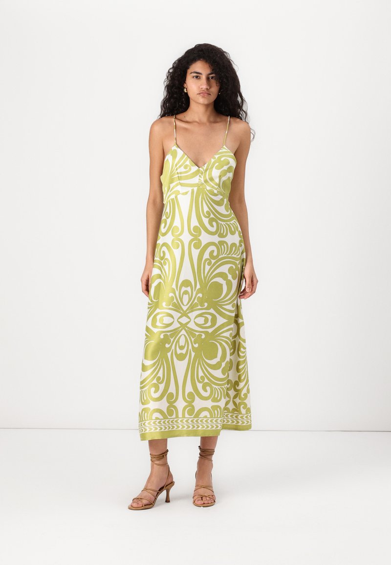 Vestido maxi com decote em V profundo, alças finas, padrão abstrato em verde e branco, e um corpete ajustado que se transforma numa saia ampla.