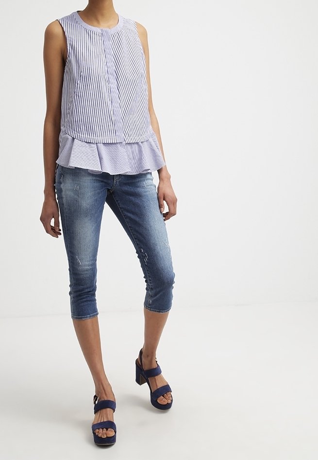 Navy and white striped sleeveless top with a flared hem, paired with light blue cropped jeans and navy platform sandals.