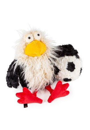 Plüschadler-Spielzeug mit flauschigen weißen und schwarzen Federn, großem gelben Schnabel, weit geöffneten Augen, leuchtend roten Füßen, das einen weichen schwarz-weißen Fußball hält.