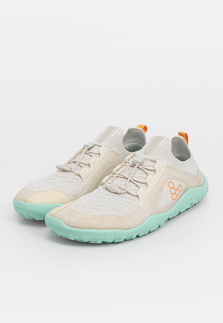 Zapatillas deportivas ligeras en beige y verde menta. Presentan un upper texturizado, cordones elásticos y un llamativo acento naranja en el talón.