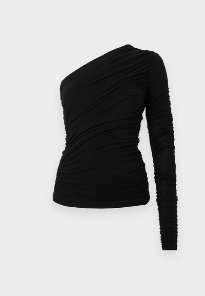 Top preto de manga comprida com um ombro exposto. Apresenta tecido franzido para textura e uma silhueta justa. Material liso e elástico.