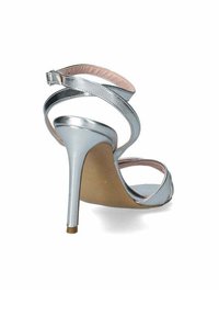 Sandal con tacco alto in argento, con cinghie incrociate, design open-toe e finitura liscia e lucida. Presenta un tacco sottile e metallico e un interno beige.
