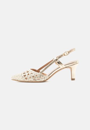 Χρυσό πέδιλο με λουράκι στον αστράγαλο, πλεκτή μυτερή μύτη και λεπτά λουράκια, μεσαίου ύψους κωνικό τακούνι και ρυθμιζόμενο κούμπωμα με αγκράφα.