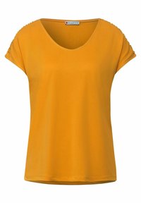 Senapsgul kortärmad skjorta med rund halsringning och samlade detaljer vid ärmsluten, etikett "Street One" vid kragen.