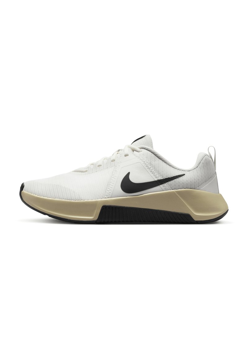 White athletic shoes with mesh upper, black Nike swoosh, neutral-toned midsole, and contrasting textured black outsole.