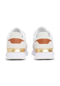 White sneakers with a textured upper, brown leather accents, and a gold metallic heel tab. Features a lightweight sole and padded collar.