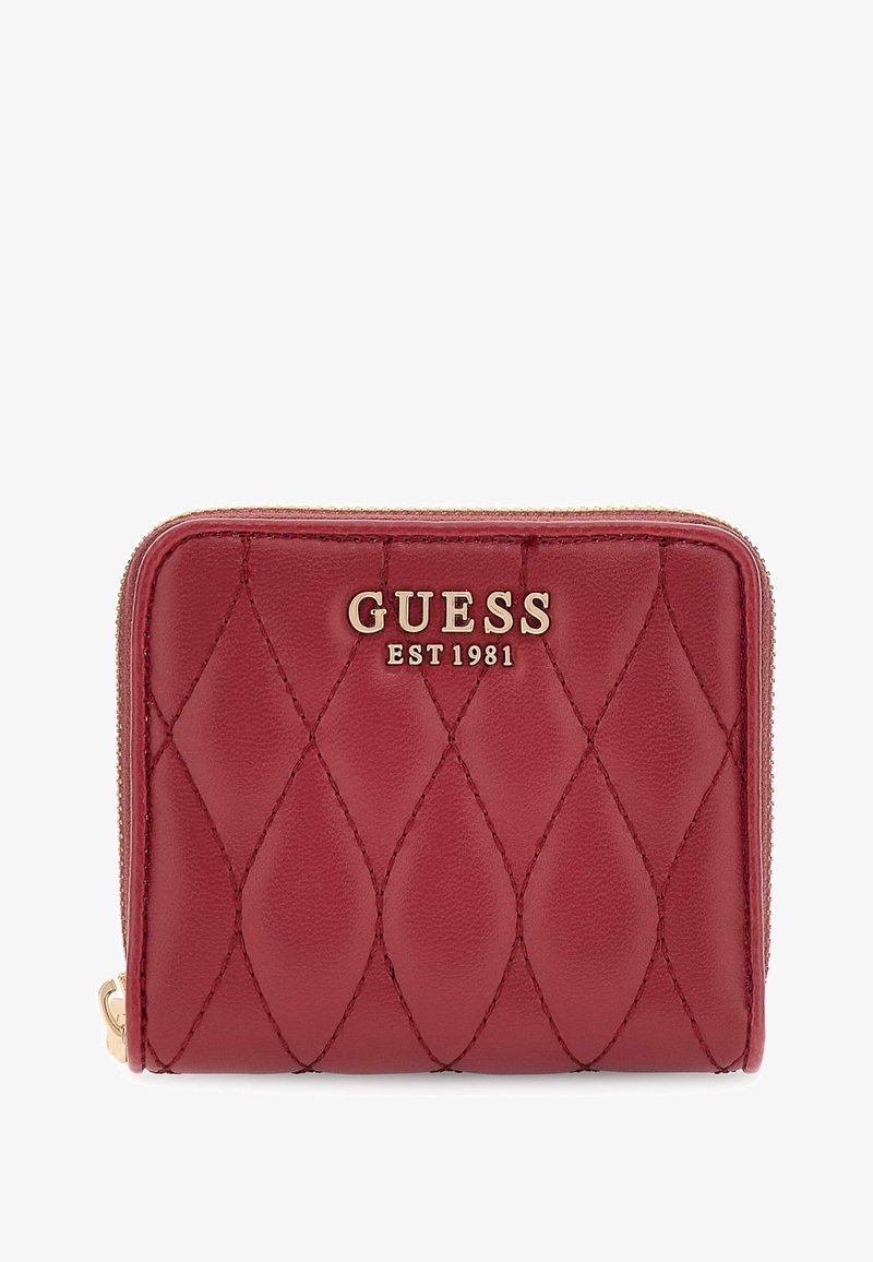 Billetera de cuero acolchado rojo con el logotipo dorado "GUESS EST 1981" y cremallera dorada sobre un fondo blanco.