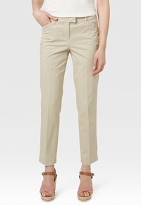 Beige bomullshöft med rak passform, med framfickor och en slät yta, i kombination med randiga espadrillosandaler.