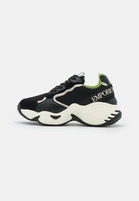 Svart och beige chunky sneaker med grön innersula, snörning och "EMPORIO" text på hälremmen.