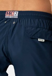 Shorts da nuoto blu con vita elastica, tasca laterale e etichetta con logo "MC2 Saint Barth"; realizzati in tessuto leggero e liscio.