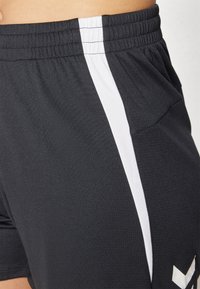 Zwarte shorts van een textuurstof, met een witte zijstrip en een klein logo aan de onderzijde. Elastische tailleband voor de juiste pasvorm.