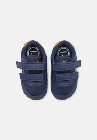 Scarpe da bambini blu navy con dettagli arancioni. Realizzate in mesh e materiali sintetici. Dotate di due cinturini in Velcro per una calzata sicura.