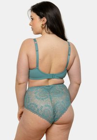 Soutien-gorge teal avec bretelles réglables et fermeture à agrafes ; culottes en dentelle assorties avec des motifs floraux et des bords festonnés, mettant en valeur des détails complexes.
