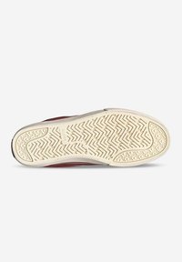 Zapatilla roja con suela de goma texturizada que presenta un patrón de espiga. La parte superior está hecha de un tejido con un acabado suave.