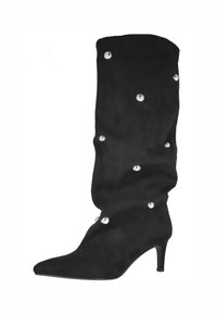 Bota de ante negra hasta la rodilla con punta afilada, tacón de aguja y tachuelas decorativas plateadas en la parte superior. Textura suave con un diseño holgado.