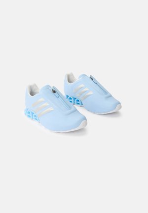 Hellblaue Sportschuhe mit weißen Streifen und Reißverschluss, ausgestattet mit einzigartigen hohl geformten federartigen Sohlen, abgebildet vor weißem Hintergrund.