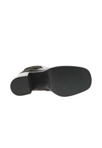 Semelle en caoutchouc noir d'une chaussure, avec un matériau supérieur à motifs et une section de talon lisse blanche. Semelle texturée pour un meilleur grip.