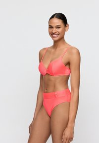 Korallinpunainen bikinisetti, jossa on topattu rintaliivit rautalankatuella ja säädettävät olkaimet sekä korkeavyötäröiset alushousut. Sileä pinta, jossa hienovarainen uritus.