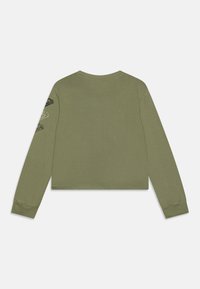 Olivovo zelené tričko s dlhým rukávom a skráteným dizajnom, s okrúhlym výstrihom a čiernymi grafickými akcentmi na oboch rukávoch. Hladká textura.