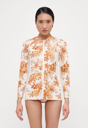 Long-sleeve rash guard in white with orange floral pattern. Features a zip front, collar, and lightweight, stretchy fabric.