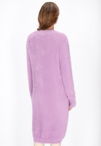 Maglione a maniche lunghe di colore lavanda, realizzato in materiale a maglia morbido, con scollatura rotonda e vestibilità rilassata che arriva a metà coscia.
