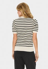 Gestreifter Pullover in Beige und Schwarz, kurze Puffärmel, gerippter Saum, weiche Stricktextur, mit Rückansicht, die die Schulterdetails und den Stofffall zeigt.
