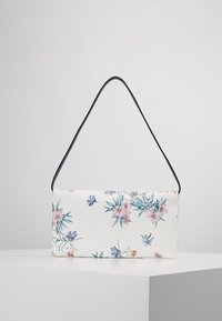 Skuldertaske med blomsterdesign i hvidt stof og sort skulderrem. Har pastelfarvede rosa og blå blomster på forsiden.
