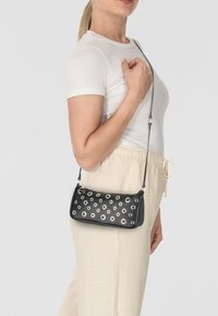 Borsa a tracolla in pelle nera con accentuazioni in metallo argentato, forma rettangolare e chiusura con cerniera. Tracolla regolabile attaccata per un indossamento versatile.