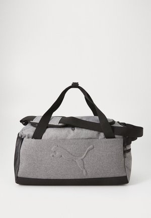 Bolso de viaje gris con acentos negros, hecho de tela duradera. Incluye un logotipo bordado prominente y correas ajustables para llevar.
