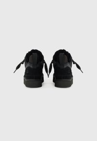 Zwarte suède sneakers met een textuur van fleece voering, platte veters, rubberen zolen en lusvormige hieltabs voor gemakkelijke aan- en uittrekken.