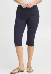 Pantaloni capri blu navy realizzati in cotone misto, con una vestibilità attillata, vita a media altezza, cuciture decorative e tasche frontali.