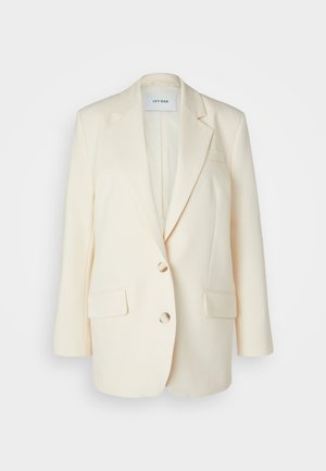 Blazer color crema realizzato in tessuto strutturato, caratterizzato da un collo a rever, due tasche anteriori, due bottoni e una vestibilità rilassata.