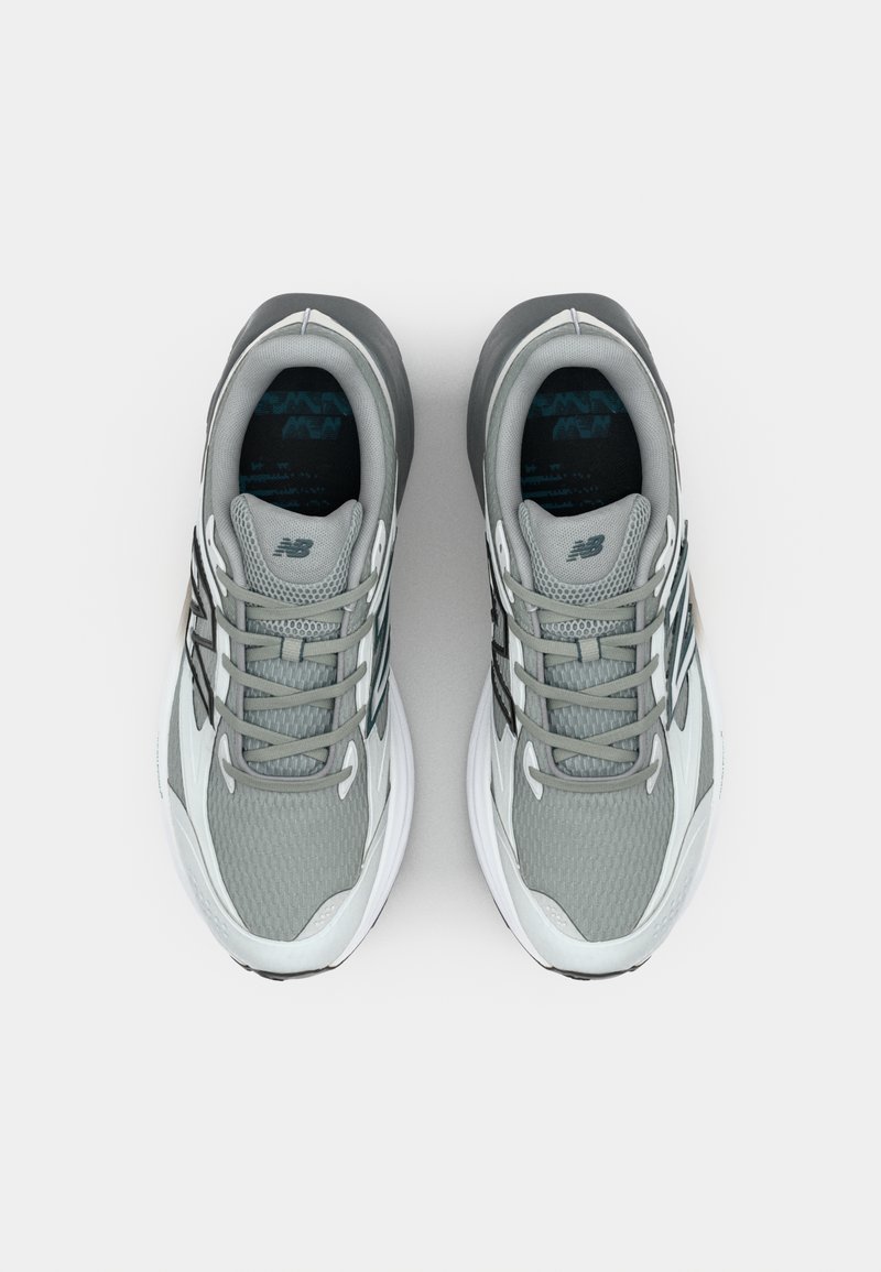 Grijze sport sneakers met een bovenwerk van gaas, versterkte neus en witte zool. Heeft zwarte accentlijnen en grijze veters.