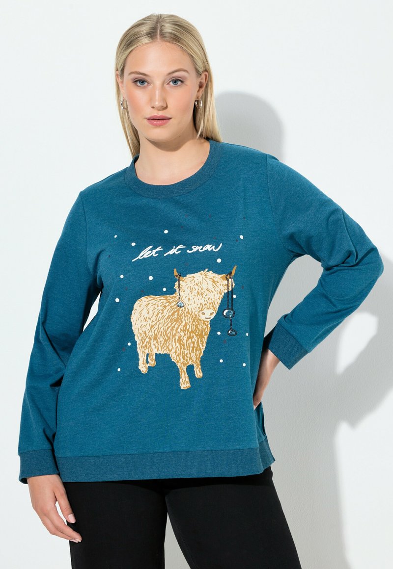 Felpa a maniche lunghe teal con un'illustrazione testurizzata di una mucca dorata e il testo "let it snow", accentuata da punti bianchi e blu.