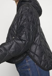 Černá prošívaná péřová bunda s přiléhavou kapucí, zipovým zapínáním a elastickým lemem. Má elegantní, lesklou tkaninu se strukturovaným vzorem.