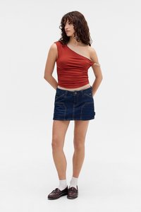 Rød top med én skulder i rynket stof, parret med en blå denim miniskjørt med frontlommer og kontrastsøm.