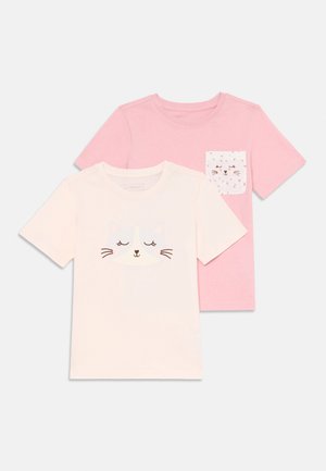 Two short-sleeve t-shirts. One white with a cat face graphic; the other light pink with a patterned pocket featuring cat designs.