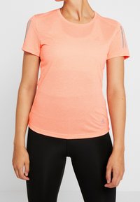 Korte mouwen sportshirt in fel neonoranje, gemaakt van een gestructureerde, vochtafvoerende stof. Kenmerkt subtiele grijze accenten en een logo.