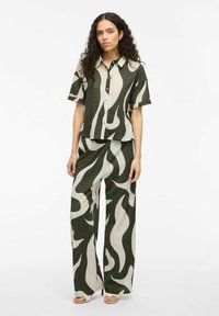 Set includes a short-sleeve button-up shirt and wide-leg pants. Features green and beige flame patterns; textured fabric with subtle pleating.