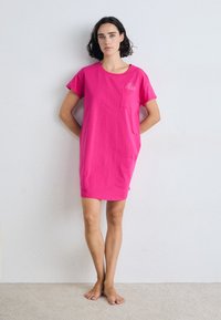 Rosa bomull t-skjortekjole med korte ermer, rund hals og en brystlomme med et enkelt grafisk design. Glatt tekstur, kne-lengde.