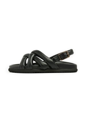 Black leather sandal with cross-strap design and adjustable buckle on the back. Flat sole with textured grip. Modern, minimalist style.